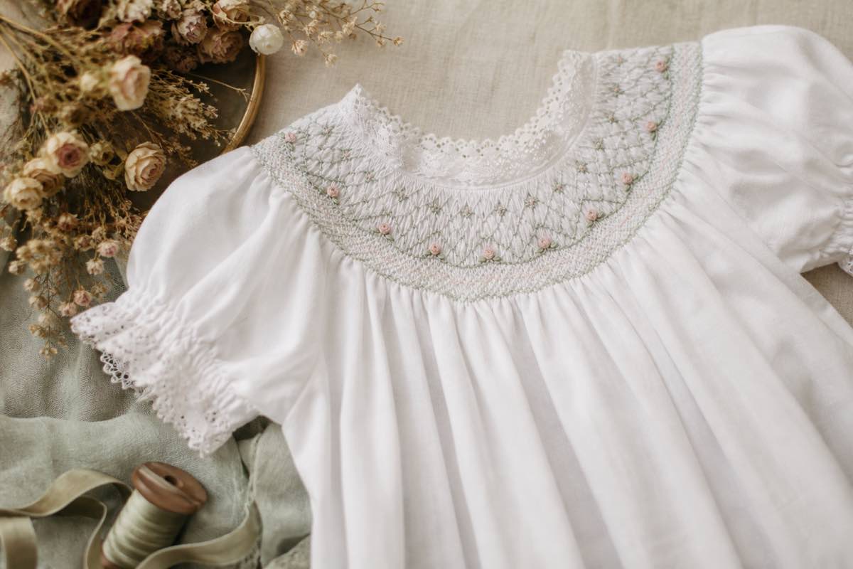 Heirloom yoke combining smocking with embroidered rose buds and satin stitch leaves