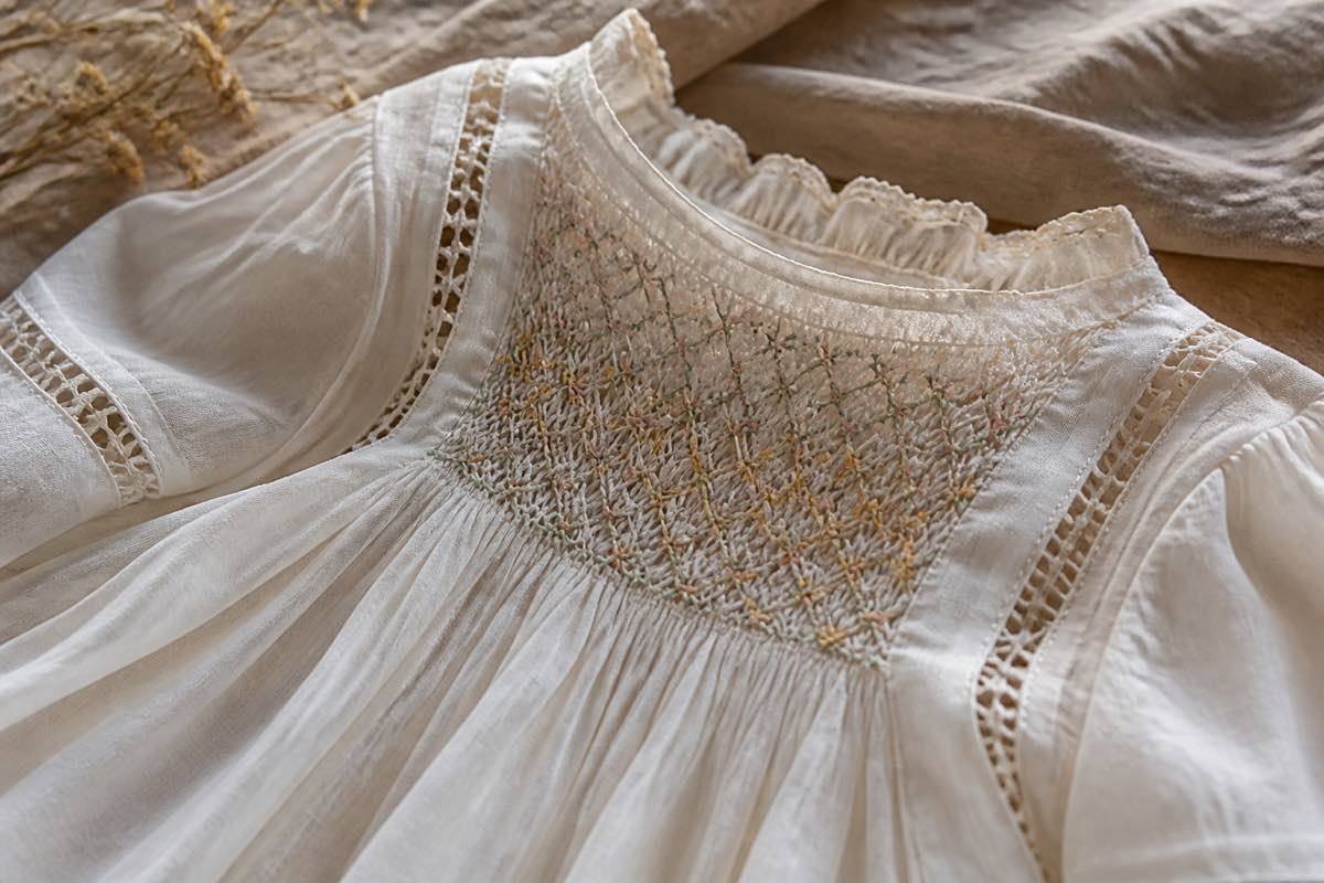 Fine heirloom garment in Swiss batiste with lace insertion and hand smocking